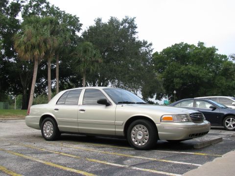 2004 Ford Crown Victoria - Silver 2004 Ford Crown Victoria parked in a lot with palm trees and another car behind it.
