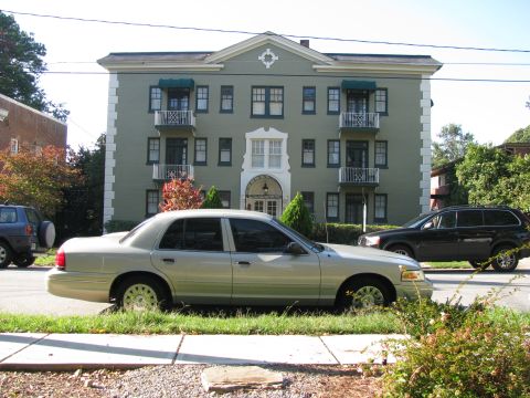 2004 Ford Crown Victoria - A silver 2004 Ford Crown Victoria is parked on a residential street in front of an apartment building.