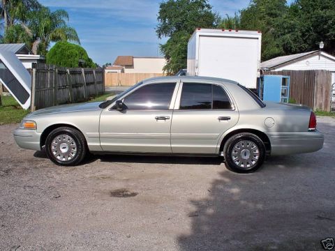 2004 Ford Crown Victoria - A silver 2004 Ford Crown Victoria sedan is parked outdoors on a sunny day.