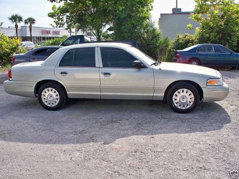 2004 Ford Crown Victoria - A silver 2004 Ford Crown Victoria is parked outdoors, showing its side profile with tinted windows and factory wheels.