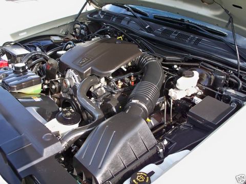 2004 Ford Crown Victoria - The engine bay of a 2004 Ford Crown Victoria is shown with the hood open, revealing the V8 engine and associated components.