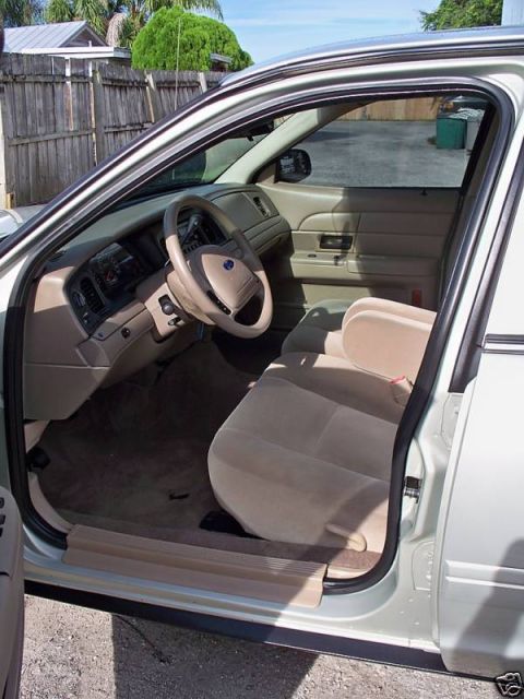 2004 Ford Crown Victoria - The interior of a 2004 Ford Crown Victoria is visible, tan upholstery and a beige dashboard.