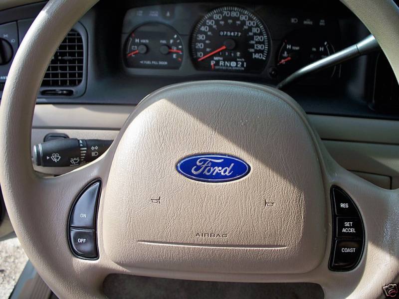 Ford Crown Victoria tan steering wheel and gauge cluster showing 75,477 miles
