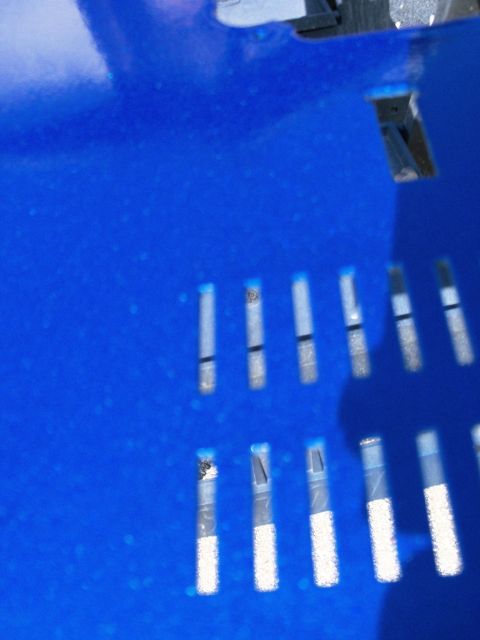 1978 Jeep CJ5 - A close-up view of a blue painted metal panel with multiple rectangular slots.