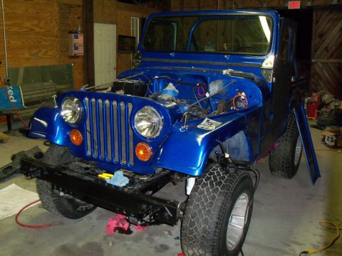 1978 Jeep CJ5 - A blue Jeep is parked inside a garage with its hood up, revealing the engine compartment.