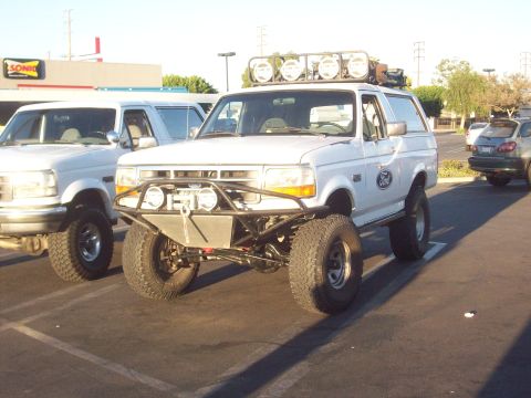 1995 Ford Bronco - Modified 1995 Ford Bronco with off-road accessories is parked in a lot next to another Bronco.