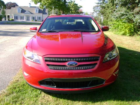 1993 Ford Taurus - Red Ford sedan with a distinctive grille and headlights, parked outdoors.