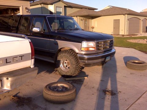 1994 Ford F-150 - This 1994 Ford F-150 pickup truck is shown in a driveway with large off-road tires.