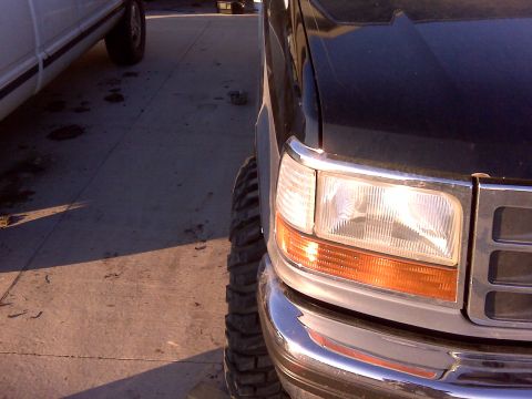 1994 Ford F-150 - Front corner view of a black 1994 Ford F-150 pickup truck, with another vehicle partially visible on the left.