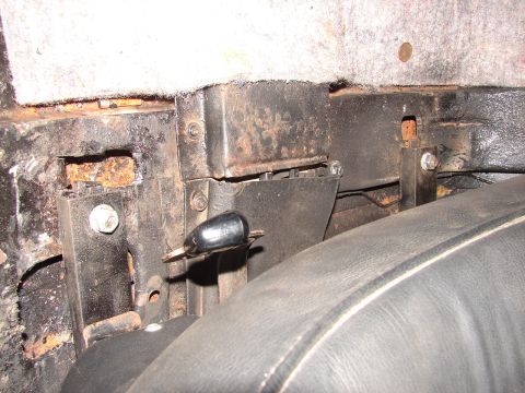 1973 Ford Ranchero - Close-up view of interior car structure with a black lever and visible rust.