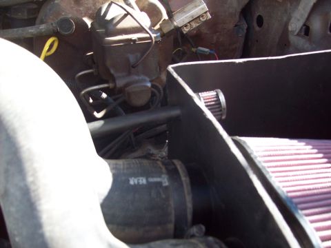 1985 Ford Bronco - Close-up of a vehicle's engine bay, highlighting the brake master cylinder and an aftermarket air intake system.