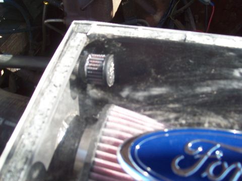 1985 Ford Bronco - Close-up of an engine's air intake system with a Ford emblem visible.