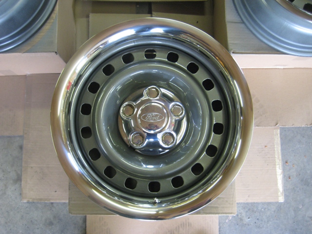 Ford wheel with chrome trim and five lug nuts