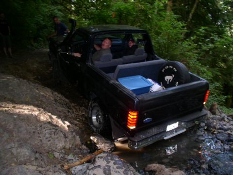 1993 Ford Bronco - 1993 Ford Bronco navigating a rocky, wet off-road trail.
