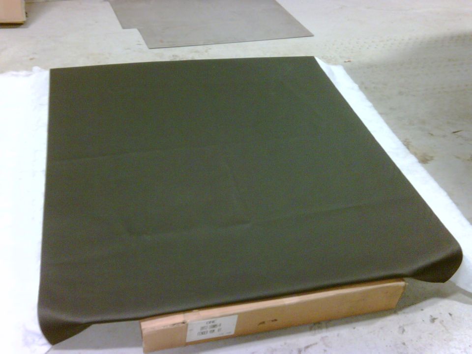Dark green headliner part with visible text on a label