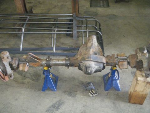 1978 Ford Bronco - A rear axle assembly is supported by blue jack stands in a workshop setting.