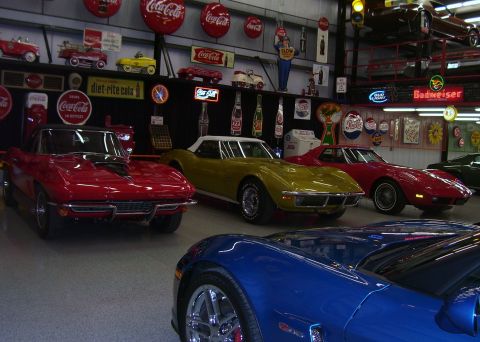 1979 Chevrolet Camaro - Multiple Chevrolet Corvettes are displayed in a garage filled with vintage memorabilia.