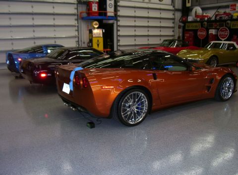 1979 Chevrolet Camaro - Several Corvettes are parked in a garage, with an orange C6 in the foreground.
