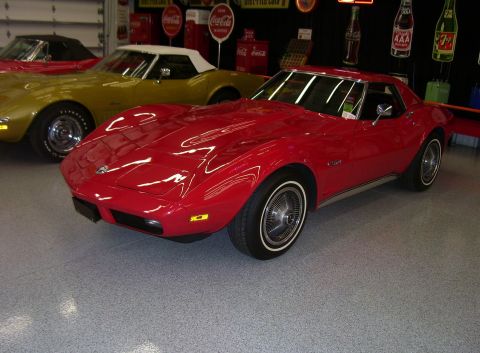 1979 Chevrolet Camaro - A red Chevrolet Corvette is parked indoors next to a yellow Corvette and another red convertible.