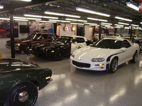 1979 Chevrolet Camaro - A collection of cars are parked in a well-lit garage, with various models visible.