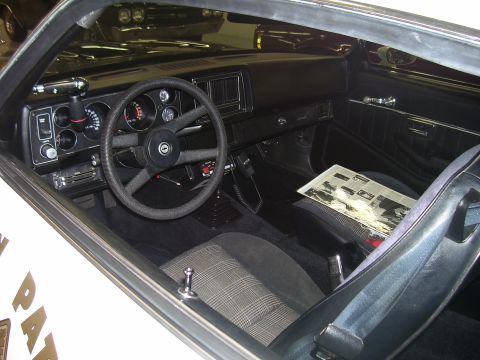 1979 Chevrolet Camaro - The interior of a 1979 Chevrolet Camaro, a police-style radio and a newspaper with car images.
