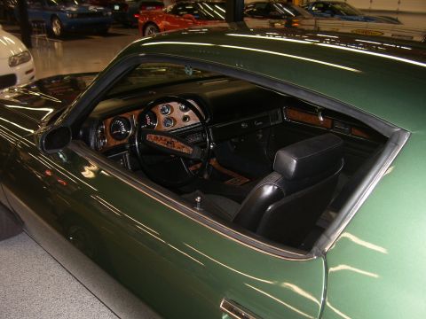 1979 Chevrolet Camaro - Interior view of a green 1979 Chevrolet Camaro, woodgrain accents and black bucket seats.