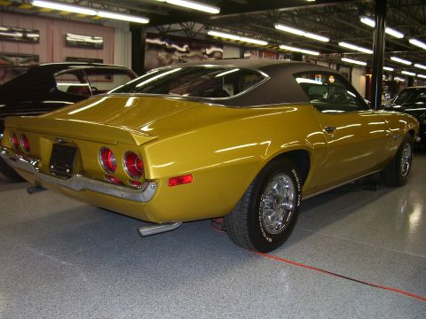 1979 Chevrolet Camaro - Rear view of a gold 1970s Chevrolet Camaro with a black vinyl top, parked indoors.