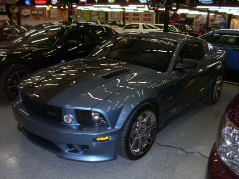 1979 Chevrolet Camaro - This blue Saleen Mustang is parked next to other vehicles in what appears to be a showroom.