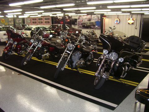 1979 Chevrolet Camaro - A collection of motorcycles are displayed in a showroom, with cars visible in the background.