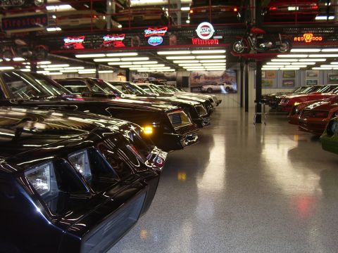 1979 Chevrolet Camaro - A collection of classic cars, including a 1979 Chevrolet Camaro, are displayed in a well-lit showroom.