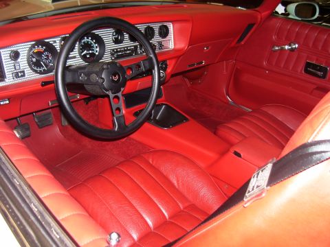 1979 Chevrolet Camaro - Interior view of a 1979 Pontiac Firebird Trans Am with red leather seats and dashboard.
