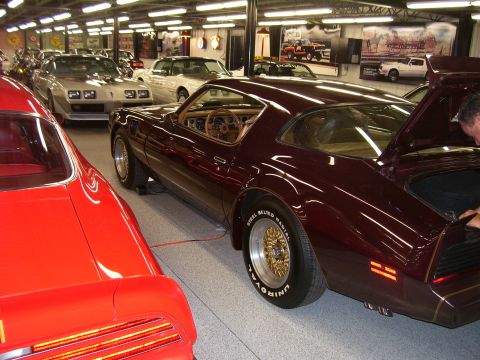 1979 Chevrolet Camaro - A maroon 1979 Chevrolet Camaro is shown from a 3q-front angle with its trunk open, parked indoors among other vehicles.