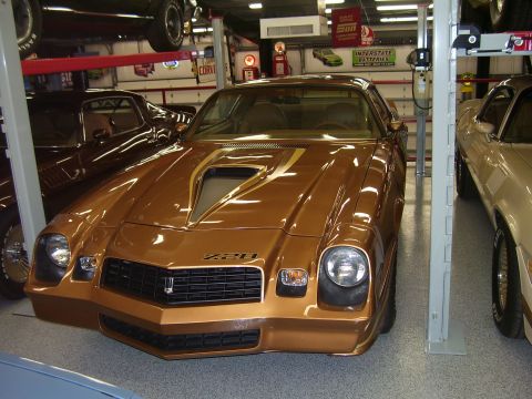 1979 Chevrolet Camaro - A gold Chevrolet Camaro Z28 is parked in a garage with other vehicles.