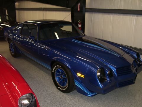 1979 Chevrolet Camaro - A blue 1979 Chevrolet Camaro is parked indoors next to a red car.