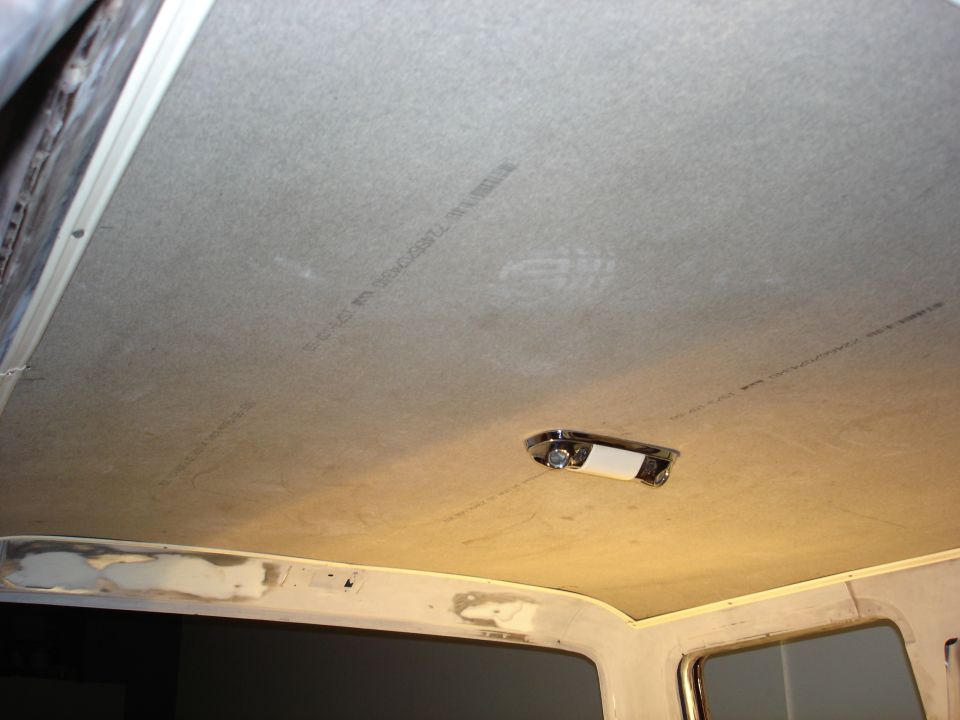 Interior ceiling of a vehicle showing a light fixture and some text on the headliner
