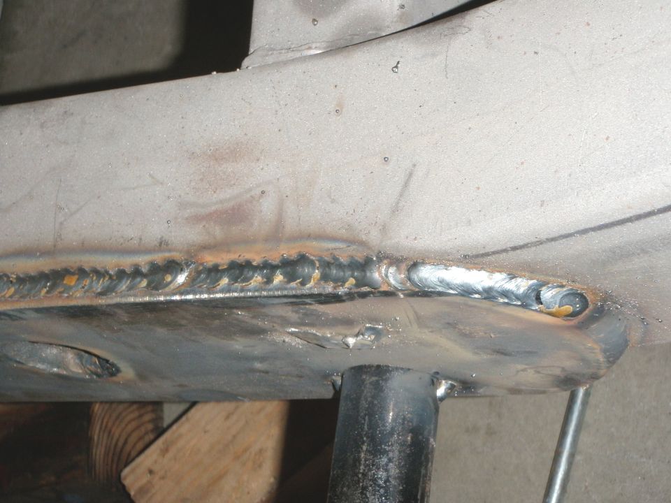 Welded metal frame section with visible weld beads and some rust spots