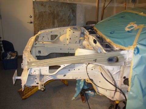 1991 Ford Taurus - The bare metal frame of a car is visible, prepped for further work in a garage setting.
