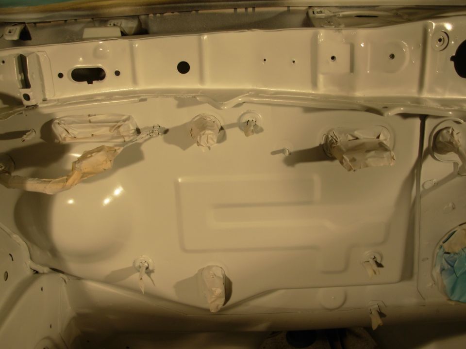 White painted engine bay with taped openings and wiring harnesses