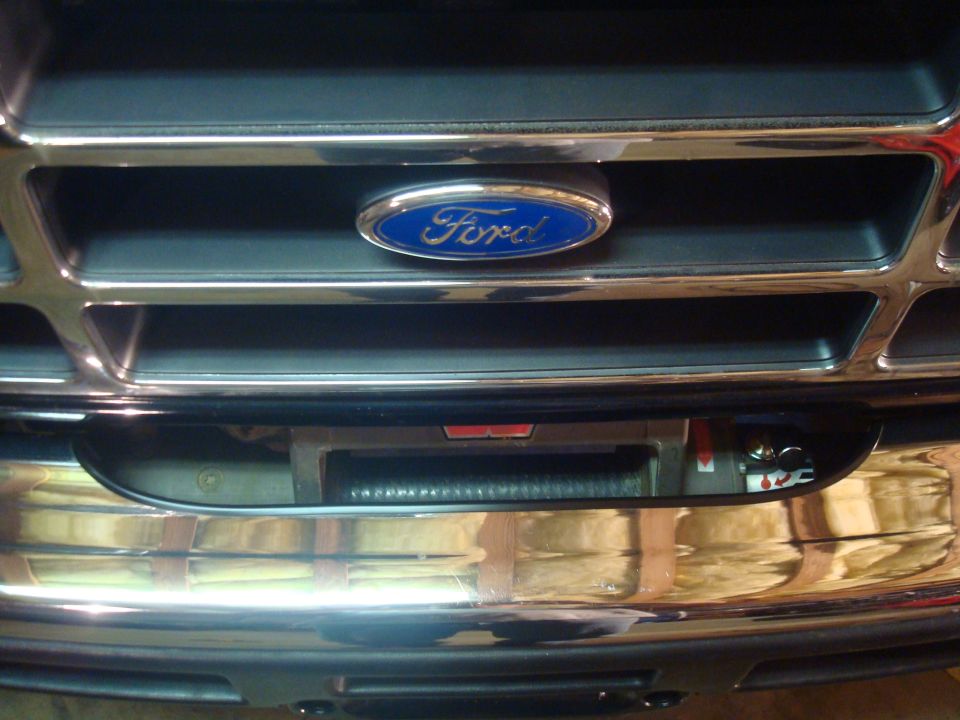 Chrome Ford grille with blue oval badge above a chrome bumper with winch behind it