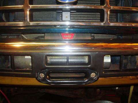 1995 Ford Bronco - Close-up of a vehicle's front bumper, highlighting an installed winch and tow hooks.