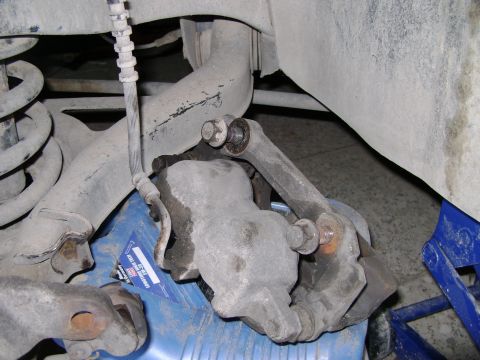 1998 Ford Crown Victoria - Close-up view of a vehicle's brake caliper and suspension components, likely during a repair.
