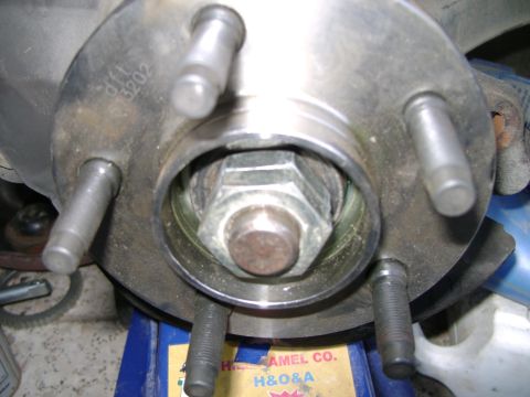 1998 Ford Crown Victoria - The wheel hub assembly shows a large central nut and multiple studs, indicating a vehicle part.