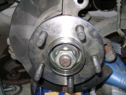 1998 Ford Crown Victoria - Close-up of a vehicle's wheel hub assembly, showing the studs and central nut.