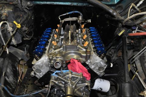 1996 Ford Bronco - Engine bay view of a V8 motor, polished components and vibrant blue valve covers.