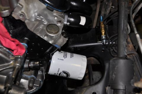 1996 Ford Bronco - An oil filter is screwed into the engine block, with a red rag nearby.