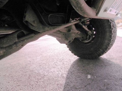 1986 Ford Bronco - Close-up view of a vehicle's undercarriage and tire.