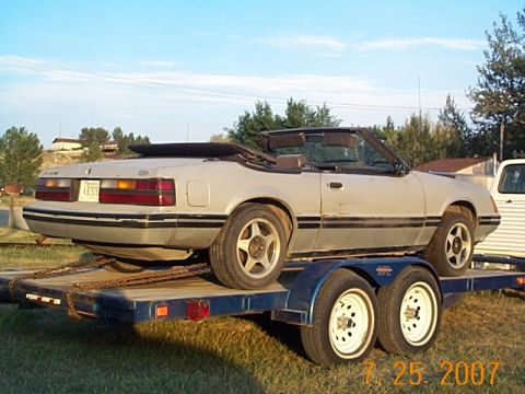 1984 Ford Mustang - 1984 Ford Mustang convertible being transported on a trailer.