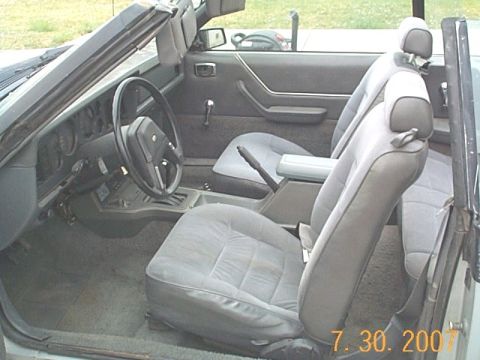 1984 Ford Mustang - Interior view of a 1984 Ford Mustang convertible, showing the seats, dashboard, and center console.