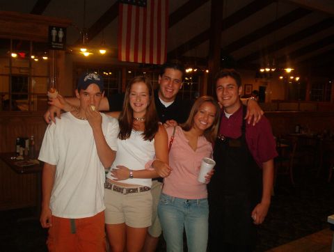 1998 Ford Taurus - A group of friends gathers for a photo inside a restaurant, with an American flag visible in the background.