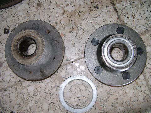 1998 Ford Crown Victoria - A used and a new wheel hub assembly are shown with a toothed ring, likely for a vehicle's ABS system.
